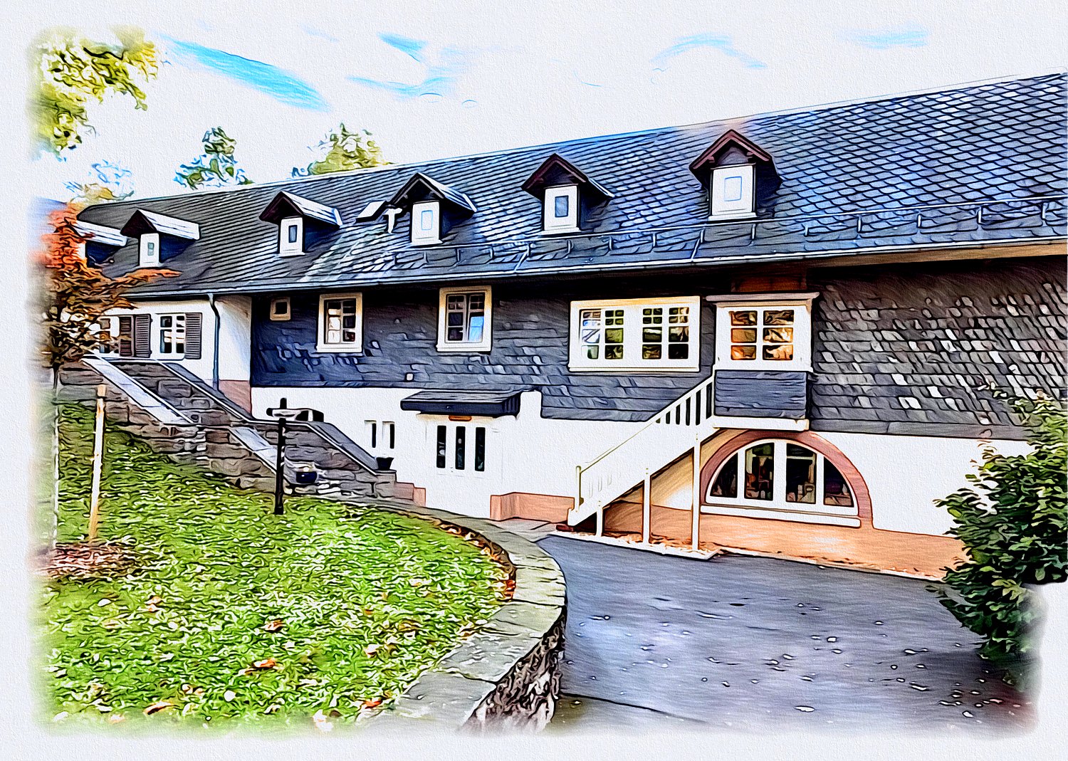 Gemaltes langes Schieferhaus mit vielen Dachgauben, Außentreppe und Rundbogenfenster, davor ein geschwungener Weg und Rasen